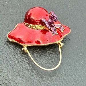 Source Unknown Red Enamel Hat Brooch with Purple Bow and Gold Trim